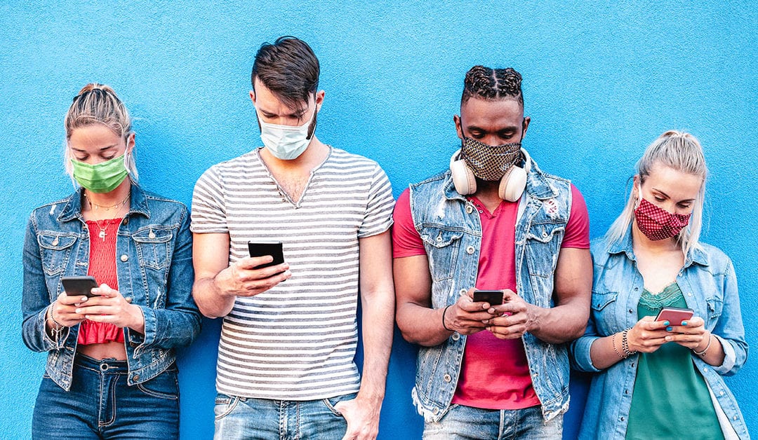 four people wearing mask on phone